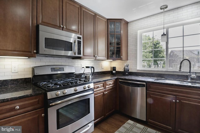4195 S Four Mile Run Dr Unit 203, Arlington, VA 22204 - kitchen with appliances with stainless steel finishes, tasteful backsplash, dark stone countertops, and decorative light fixtures