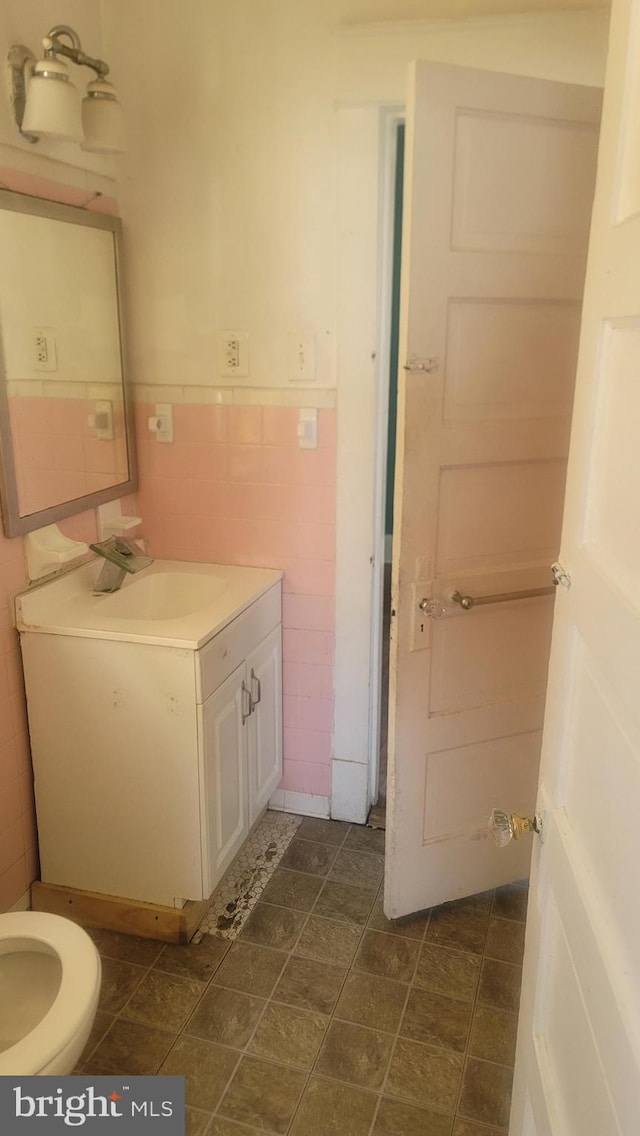 1324 S St SE, Washington, DC 20020 - half bath featuring vanity, tile walls, and wainscoting