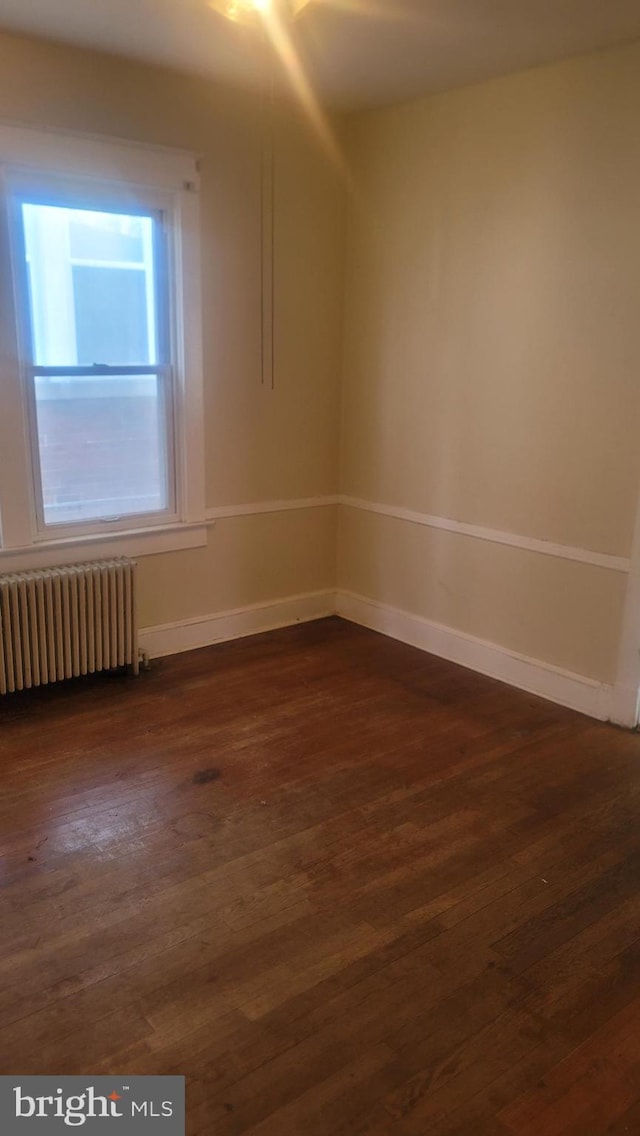 1324 S St SE, Washington, DC 20020 - unfurnished room featuring radiator heating unit and dark wood-style flooring