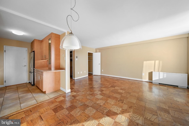 6641 Wakefield Dr Unit 405, Alexandria, VA 22307 - kitchen with freestanding refrigerator, light countertops, hanging light fixtures, glass insert cabinets, and radiator