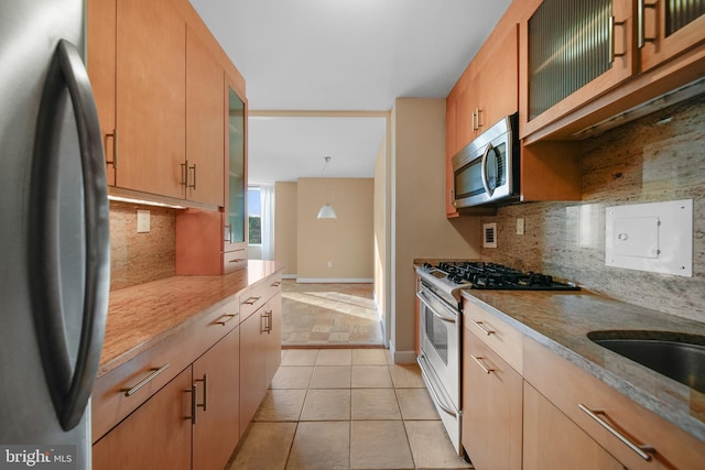 6641 Wakefield Dr Unit 405, Alexandria, VA 22307 - kitchen with stainless steel appliances, backsplash, light tile patterned floors, glass insert cabinets, and light stone countertops