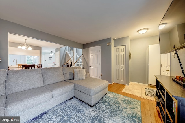 3459 Caledonia Cir, Woodbridge, VA 22192 - living room with light wood finished floors, stairs, ceiling fan, and a chandelier