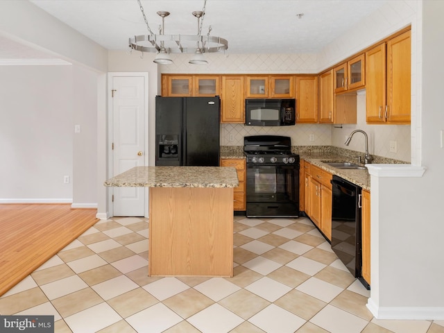 8730 Thornbrook Dr, Odenton, MD 21113 - kitchen with black appliances, a center island, backsplash, light stone counters, and glass insert cabinets