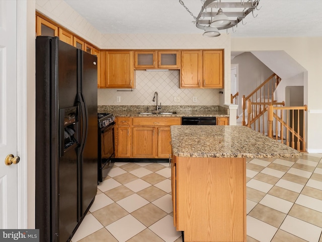 8730 Thornbrook Dr, Odenton, MD 21113 - kitchen with black appliances, a center island, tasteful backsplash, glass insert cabinets, and light stone counters
