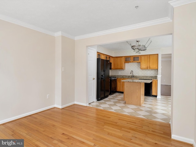 8730 Thornbrook Dr, Odenton, MD 21113 - kitchen featuring black appliances, a kitchen island, light wood-style floors, crown molding, and a chandelier