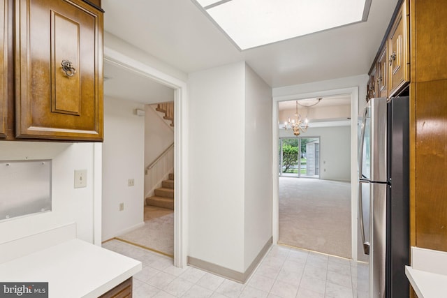3357 S Leisure World Blvd Unit 96-C, Silver Spring, MD 20906 - kitchen featuring freestanding refrigerator, light colored carpet, light countertops, brown cabinets, and a chandelier