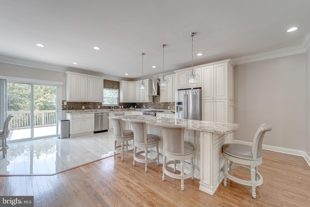 8 Ashley Ct, Stafford, VA 22554 - kitchen with premium appliances, wall chimney exhaust hood, crown molding, a kitchen island, and decorative backsplash