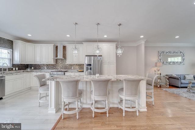 8 Ashley Ct, Stafford, VA 22554 - kitchen with appliances with stainless steel finishes, wall chimney range hood, a kitchen island, crown molding, and healthy amount of natural light