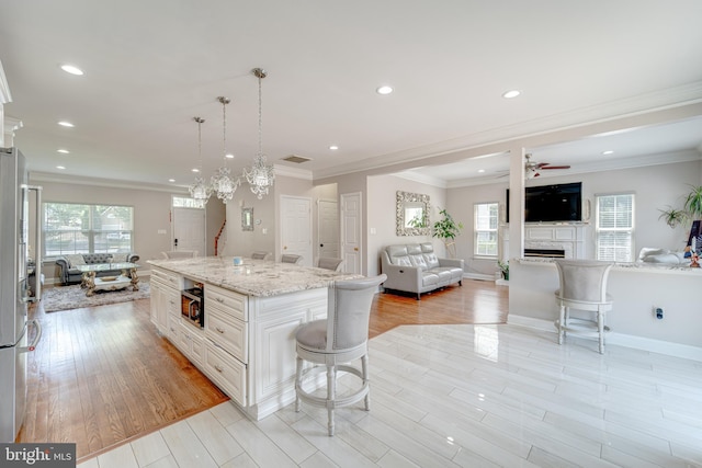 8 Ashley Ct, Stafford, VA 22554 - kitchen with open floor plan, a kitchen breakfast bar, healthy amount of natural light, a fireplace, and ornamental molding