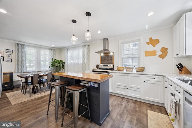 927 Drexel Ave, Drexel Hill, PA 19026 - kitchen with wall chimney exhaust hood, stainless steel appliances, ornamental molding, white cabinets, and plenty of natural light
