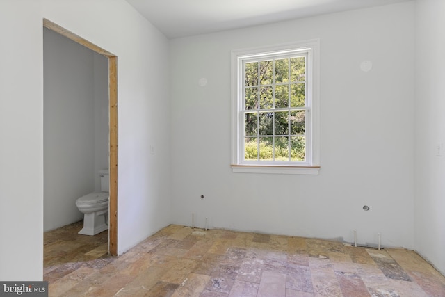 453 Bayard Rd, Kennett Square, PA 19348 - unfurnished bedroom featuring stone finish floors, multiple windows, and connected bathroom