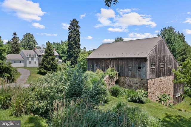 453 Bayard Rd, Kennett Square, PA 19348 - view of side of home featuring an outdoor structure, stone siding, and a metal roof