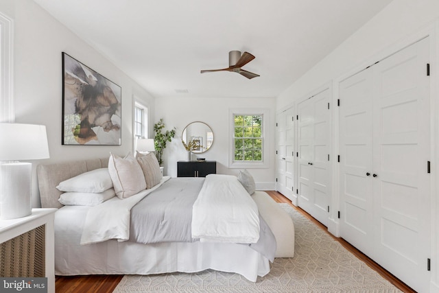 3518 35th St NW, Washington, DC 20016 - bedroom with multiple windows, wood finished floors, two closets, and ceiling fan