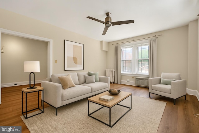 1954 Columbia Rd NW Unit 112, Washington, DC 20009 - living area with radiator heating unit, ceiling fan, wood finished floors, and a wall unit AC