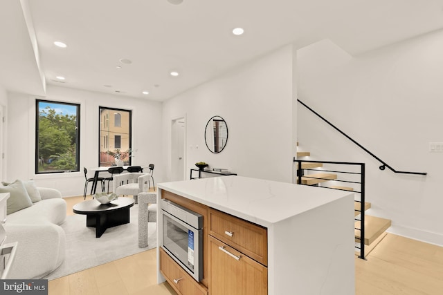 507 L St NE Unit 3B, Washington, DC 20002 - kitchen featuring stainless steel microwave, open floor plan, recessed lighting, a center island, and light wood-style floors