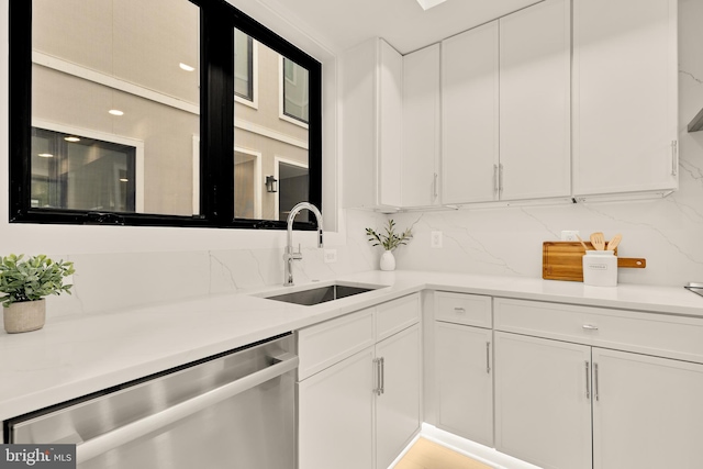 507 L St NE Unit 3B, Washington, DC 20002 - kitchen featuring stainless steel dishwasher, white cabinets, decorative backsplash, and light countertops