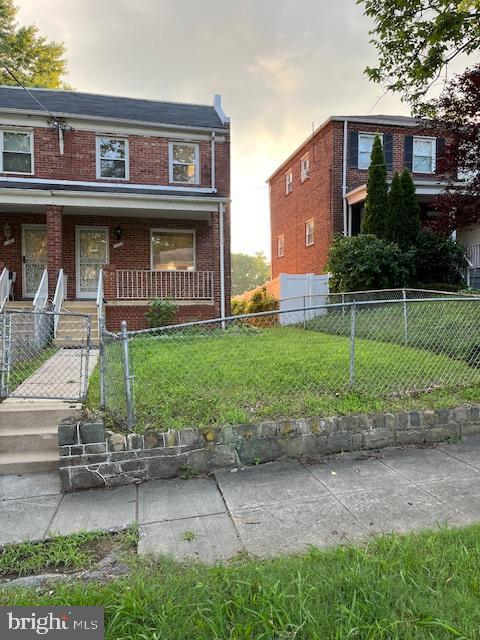 1119 Branch Ave SE, Washington, DC 20019 - view of property with covered porch, brick siding, and a fenced front yard
