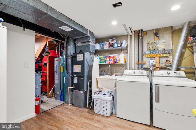 9304 Taverney Ter, Gaithersburg, MD 20879 - laundry room with washing machine and clothes dryer, water heater, wood finished floors, and heating unit