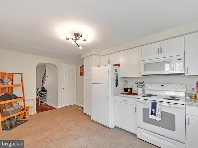 41 W George St, York, PA 17408 - kitchen with white appliances, arched walkways, light countertops, white cabinetry, and a chandelier