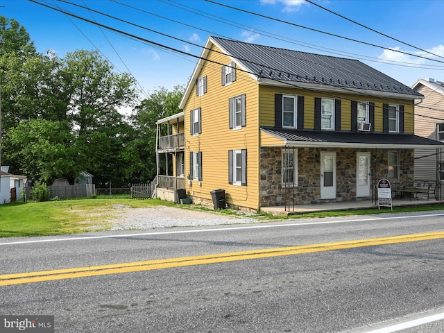 41 W George St, York, PA 17408 - view of front of property featuring stone siding, covered porch, a balcony, a metal roof, and a standing seam roof
