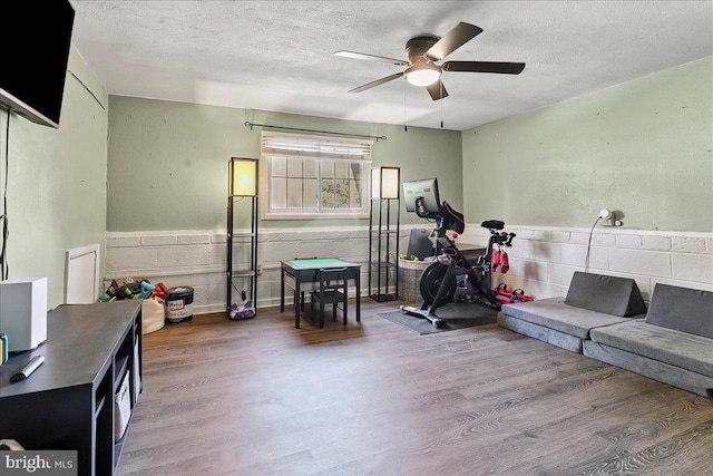 15 Pearson Dr, Springfield, PA 19064 - living area featuring wood finished floors, a textured ceiling, a ceiling fan, and wainscoting