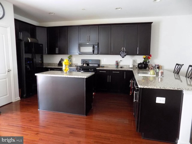 9545 Elizabeth Howe Ln, Owings Mills, MD 21117 - kitchen featuring black appliances, light stone counters, a peninsula, dark wood-type flooring, and a center island