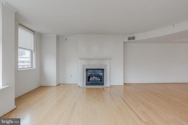 3835 9th St N Unit 1001W, Arlington, VA 22203 - unfurnished living room featuring wood finished floors and a fireplace with raised hearth