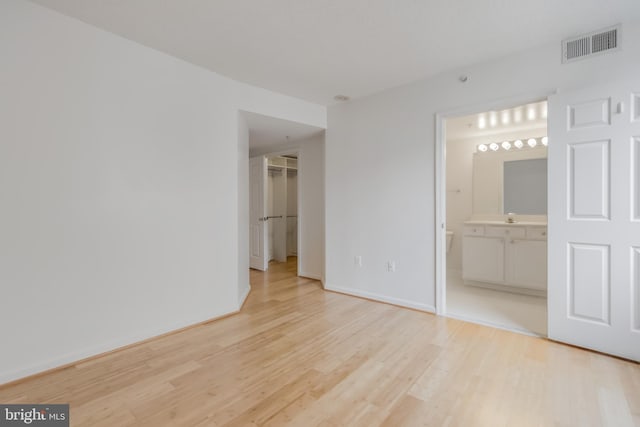 3835 9th St N Unit 1001W, Arlington, VA 22203 - unfurnished bedroom featuring light wood-style flooring, a spacious closet, and connected bathroom