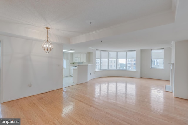 3835 9th St N Unit 1001W, Arlington, VA 22203 - unfurnished living room featuring light wood-style floors, a chandelier, and ornamental molding
