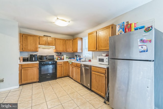5349 Call Pl SE, Washington, DC 20019 - kitchen featuring stainless steel appliances, under cabinet range hood, light countertops, and light tile patterned floors
