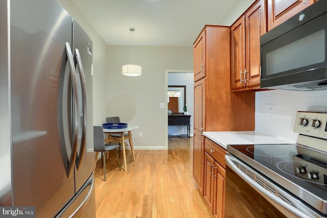 1339 Georgetown Cir, Carlisle, PA 17013 - kitchen featuring appliances with stainless steel finishes, brown cabinets, decorative backsplash, light wood finished floors, and light countertops