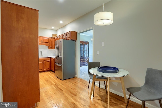 1339 Georgetown Cir, Carlisle, PA 17013 - kitchen with freestanding refrigerator, light wood-type flooring, brown cabinets, pendant lighting, and recessed lighting