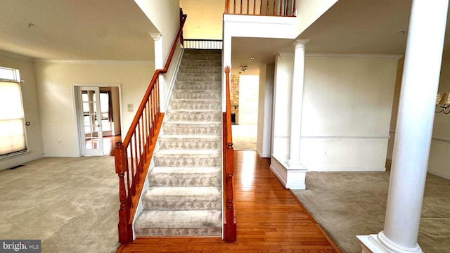 10005 Erion Ct, Bowie, MD 20721 - staircase featuring decorative columns, crown molding, carpet flooring, and wood finished floors