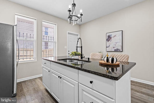 2328 E Hoffman St, Baltimore, MD 21213 - kitchen with freestanding refrigerator, dark wood-style floors, white cabinetry, and plenty of natural light