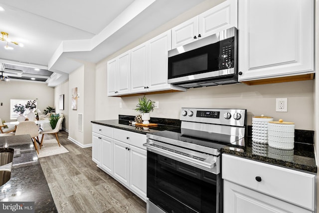 2328 E Hoffman St, Baltimore, MD 21213 - kitchen featuring stainless steel appliances, wood finished floors, white cabinets, and dark stone countertops