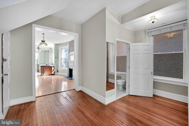 1223 Euclid St NW, Washington, DC 20009 - unfurnished bedroom with wood-type flooring, a fireplace with flush hearth, and a chandelier