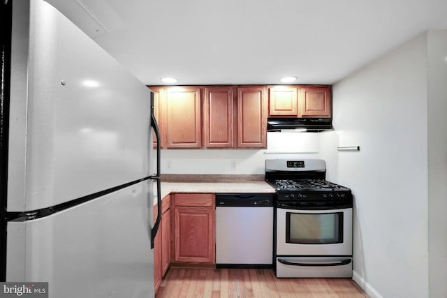 1223 Euclid St NW, Washington, DC 20009 - kitchen featuring freestanding refrigerator, dishwasher, stainless steel gas range, under cabinet range hood, and light countertops