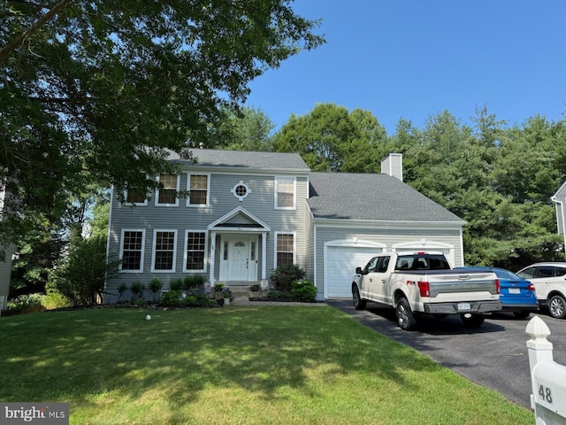 48 Blossom Wood Ct, Stafford, VA 22554 - colonial house with an attached garage, a chimney, a front lawn, driveway, and roof with shingles