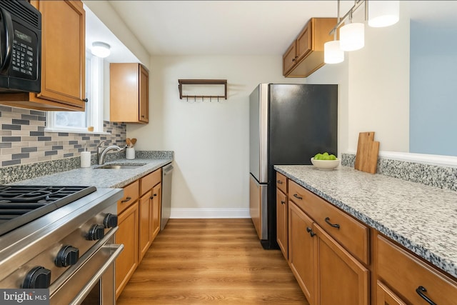 2504 Parkview Rd, Baltimore, MD 21207 - kitchen with stainless steel appliances, light wood-style flooring, brown cabinetry, and tasteful backsplash