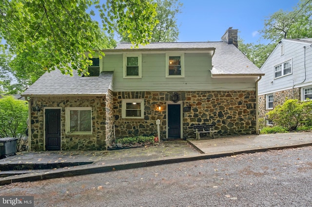 2504 Parkview Rd, Baltimore, MD 21207 - view of front of house with stone siding, a chimney, and roof with shingles