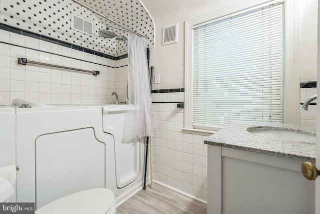 2504 Parkview Rd, Baltimore, MD 21207 - full bathroom featuring tile walls, wood finished floors, vanity, and shower / tub combo with curtain