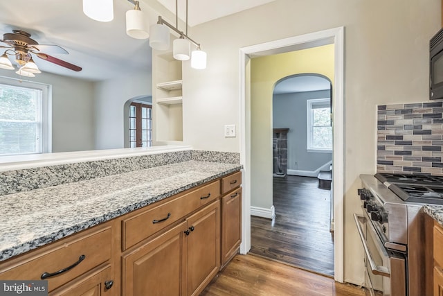 2504 Parkview Rd, Baltimore, MD 21207 - kitchen featuring arched walkways, stainless steel range, a ceiling fan, and brown cabinets