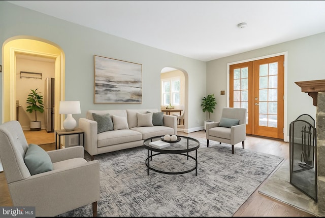 2504 Parkview Rd, Baltimore, MD 21207 - living room featuring arched walkways, light wood-style flooring, and french doors