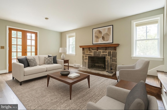 2504 Parkview Rd, Baltimore, MD 21207 - living area with light wood finished floors, french doors, and a stone fireplace