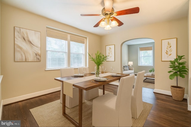 2504 Parkview Rd, Baltimore, MD 21207 - dining space with arched walkways, ceiling fan, and dark wood-style floors