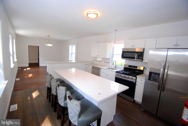 217 Wood St, Burlington, NJ 08016 - kitchen with stainless steel appliances, light countertops, backsplash, decorative light fixtures, and a kitchen bar