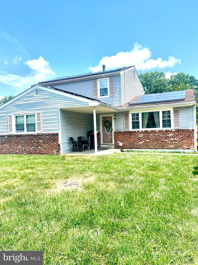 505 N Atlantic Ave, Stratford, NJ 08084 - traditional-style house featuring solar panels, brick siding, a front lawn, and a patio