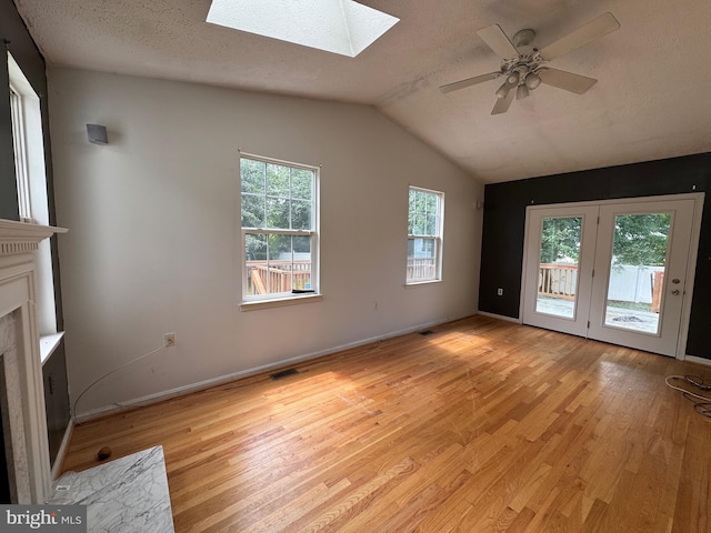 1809 Labrott Ln, Annapolis, MD 21401 - unfurnished living room with a skylight, light wood-style flooring, a ceiling fan, a fireplace with flush hearth, and vaulted ceiling