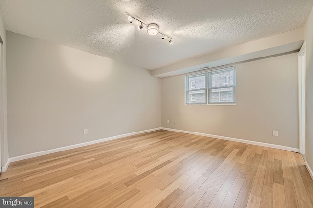 11921 Tarragon Rd Unit F, Reisterstown, MD 21136 - unfurnished bedroom featuring a textured ceiling, light wood finished floors, and rail lighting
