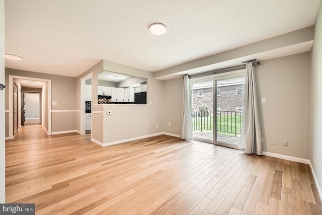 11921 Tarragon Rd Unit F, Reisterstown, MD 21136 - unfurnished living room with light wood-type flooring and a textured ceiling